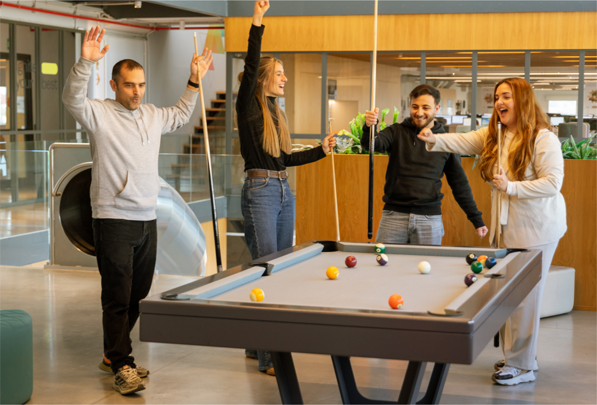 equipo de Beself Brands celebrando al lado de una mesa de billar
